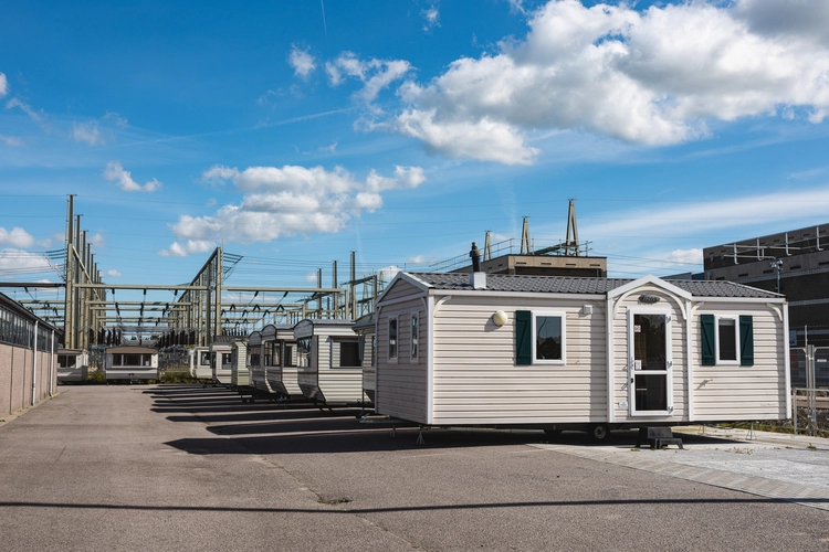 Mobile home chargé sur un porte-char pour un convoi de livraison